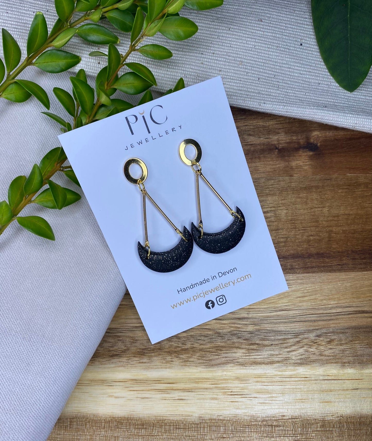 Statement dangles - black and gold glitter moons hanging from gold metal bars