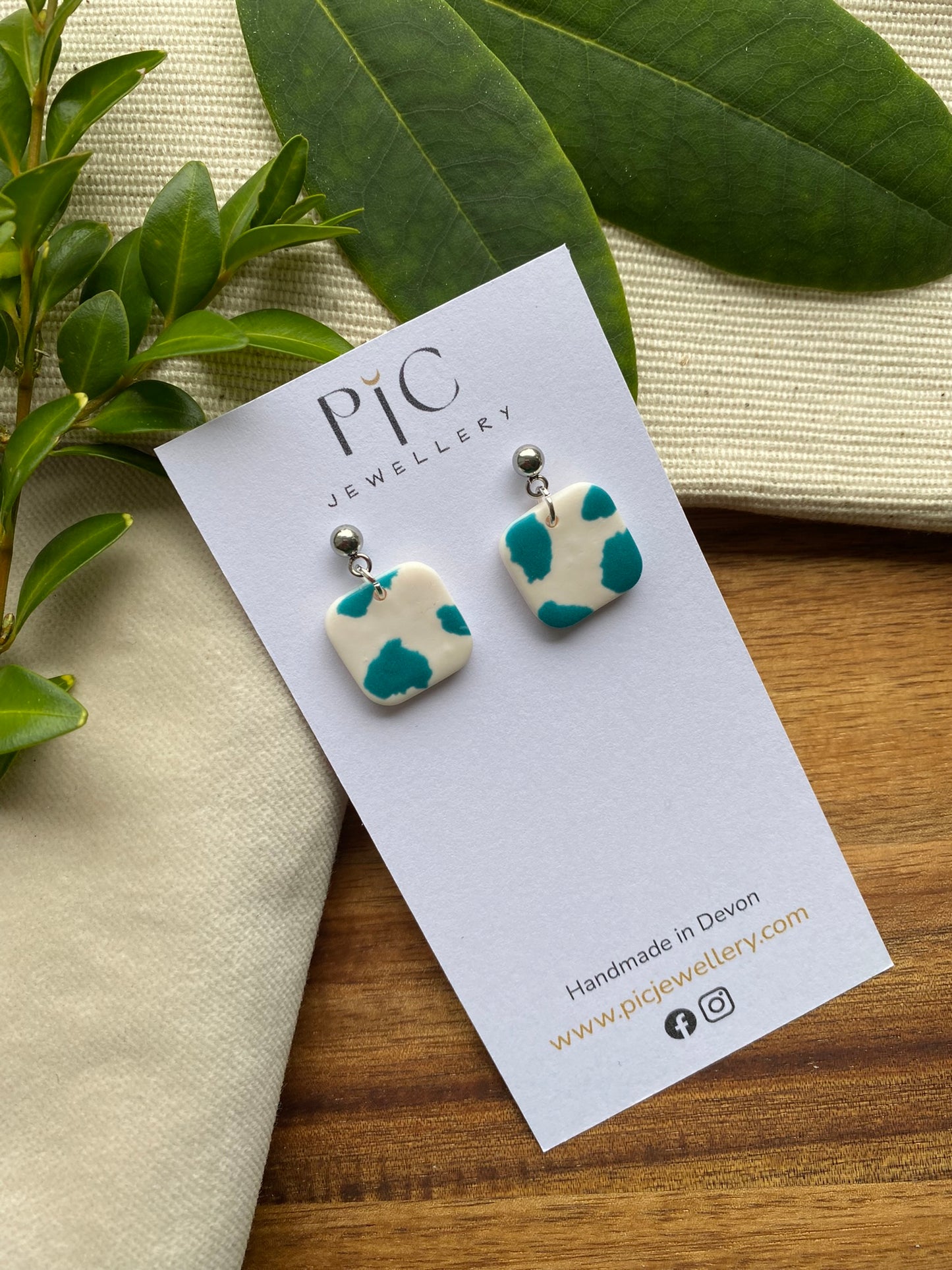 Dinky dangles - white and teal cow print squares
