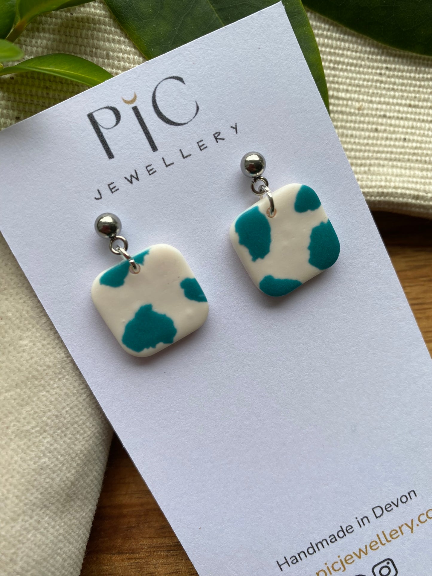 Dinky dangles - white and teal cow print squares