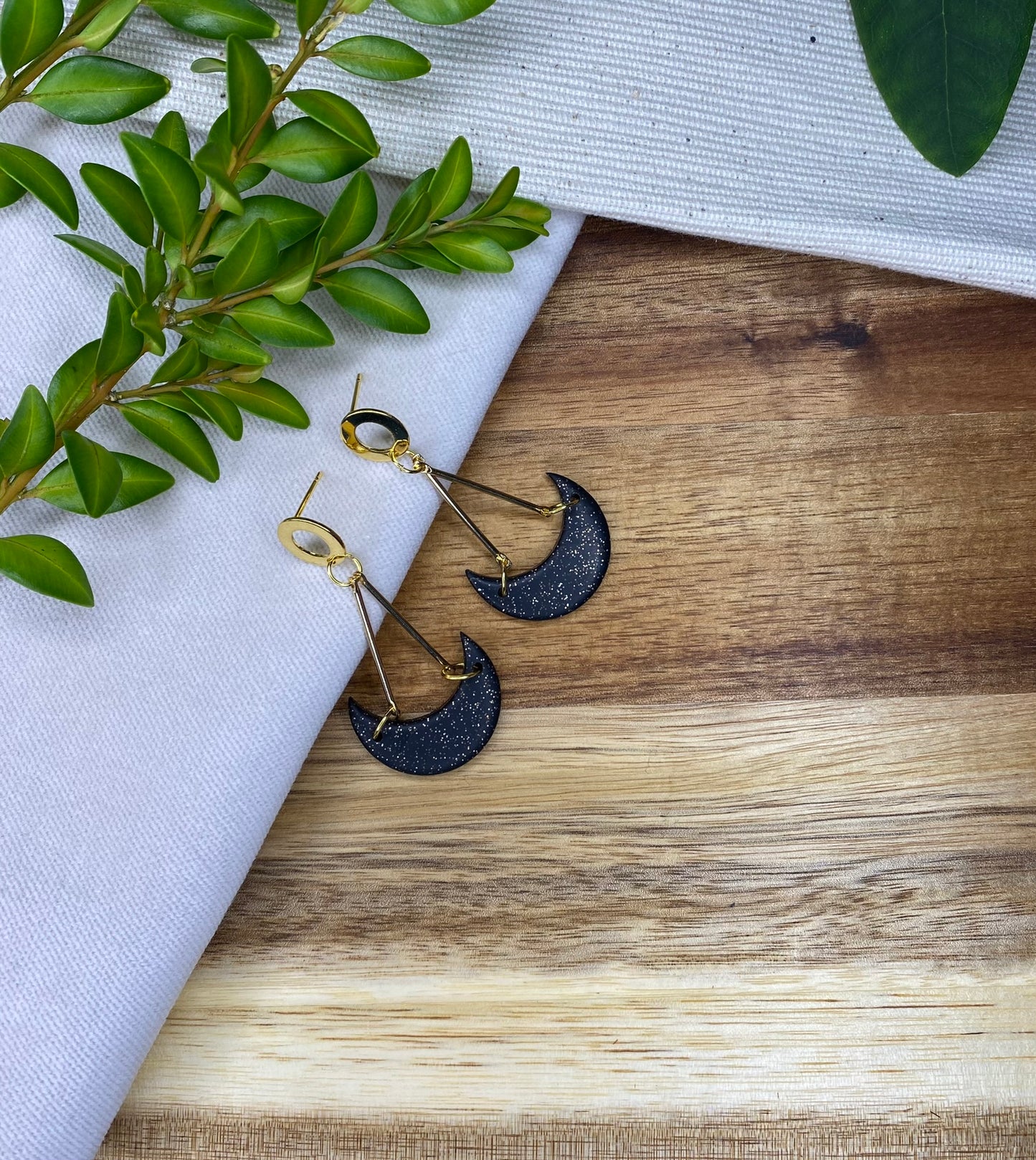 Statement dangles - black and gold glitter moons hanging from gold metal bars