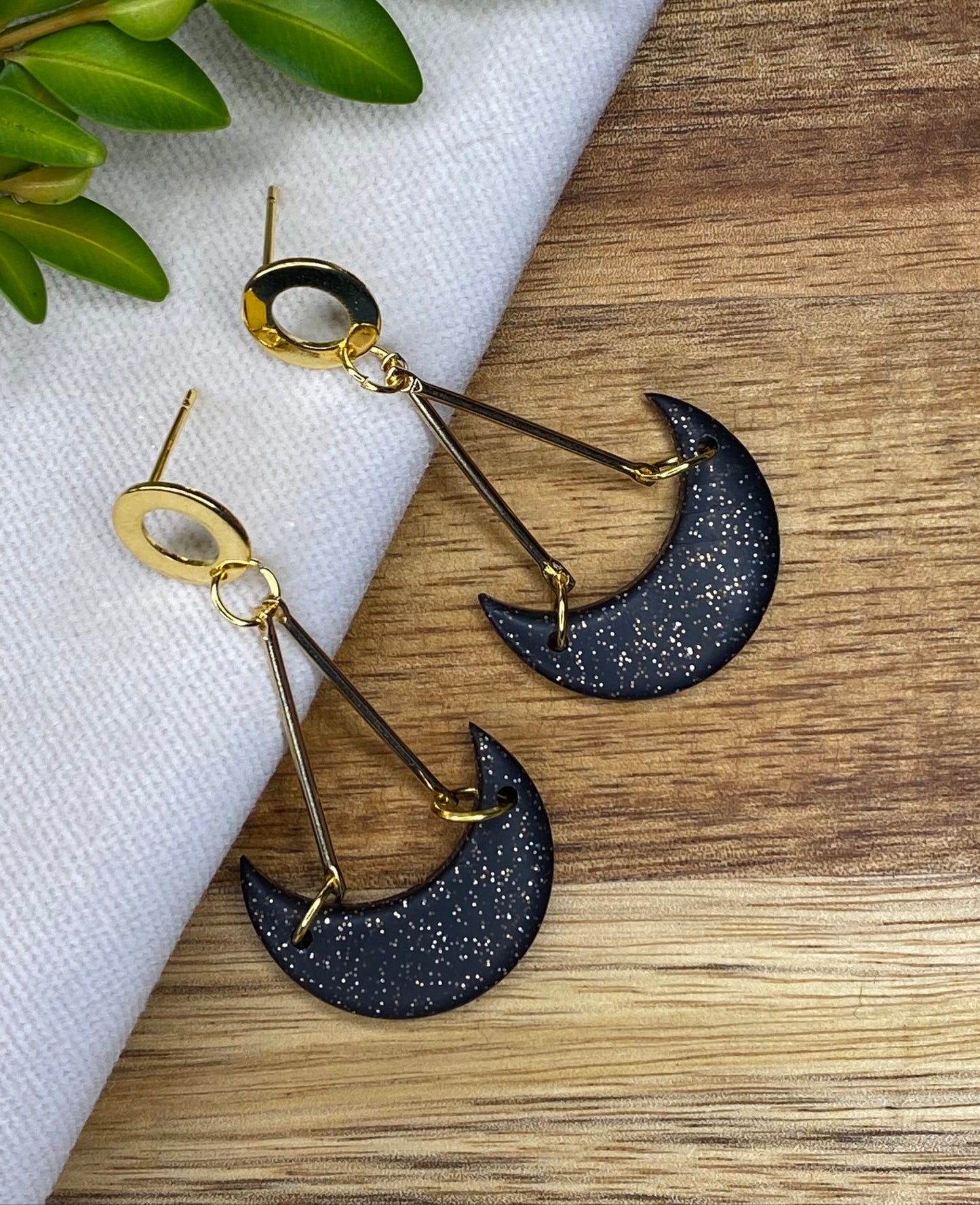 Statement dangles - black and gold glitter moons hanging from gold metal bars