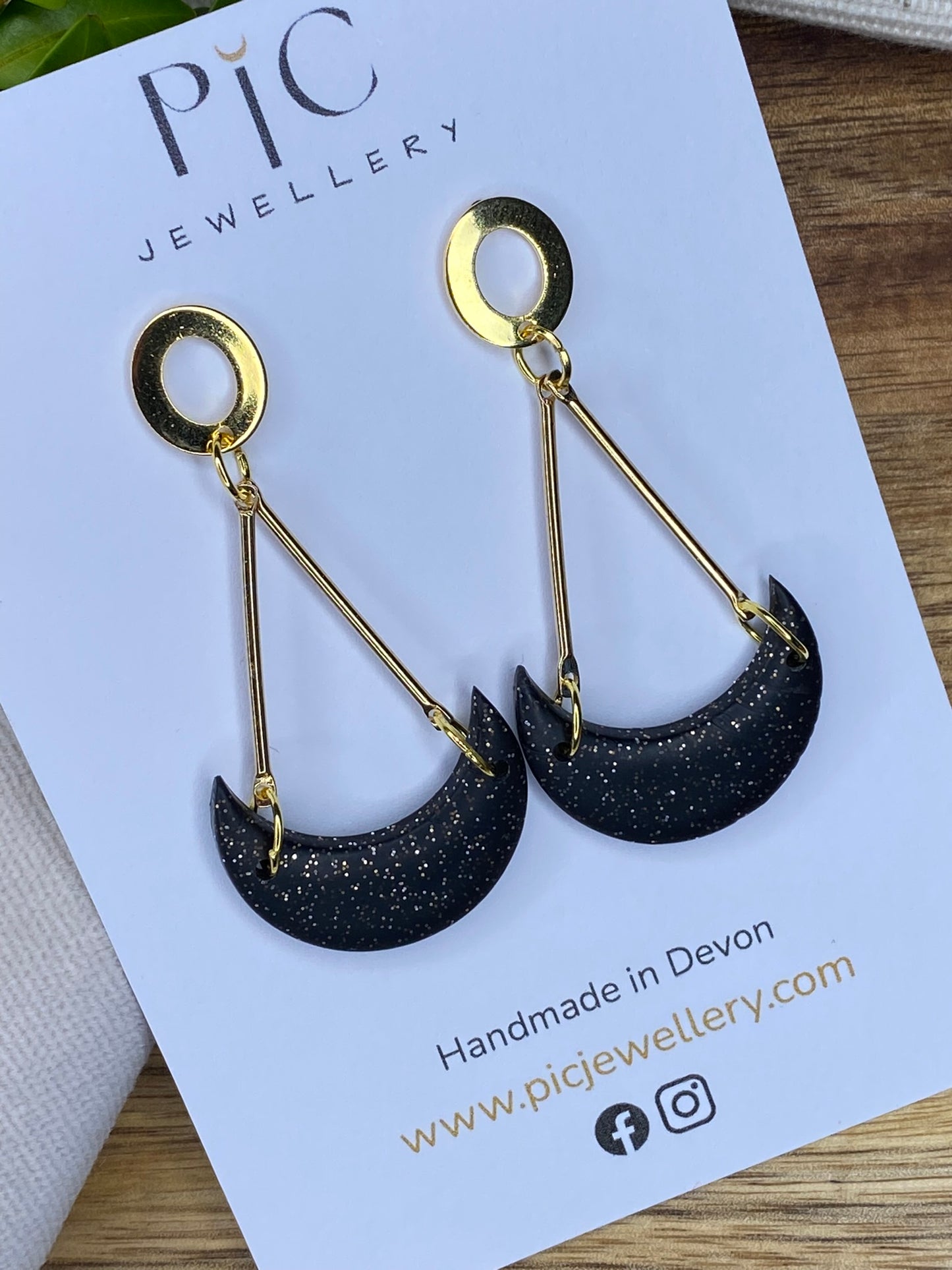 Statement dangles - black and gold glitter moons hanging from gold metal bars